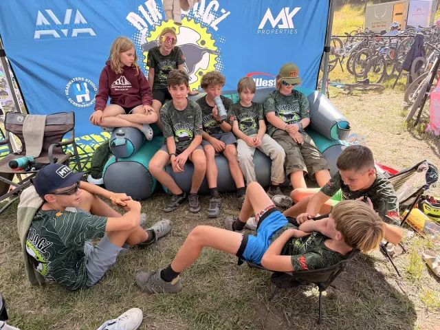 Dirt Dogz teammates relaxing together beside the team banner